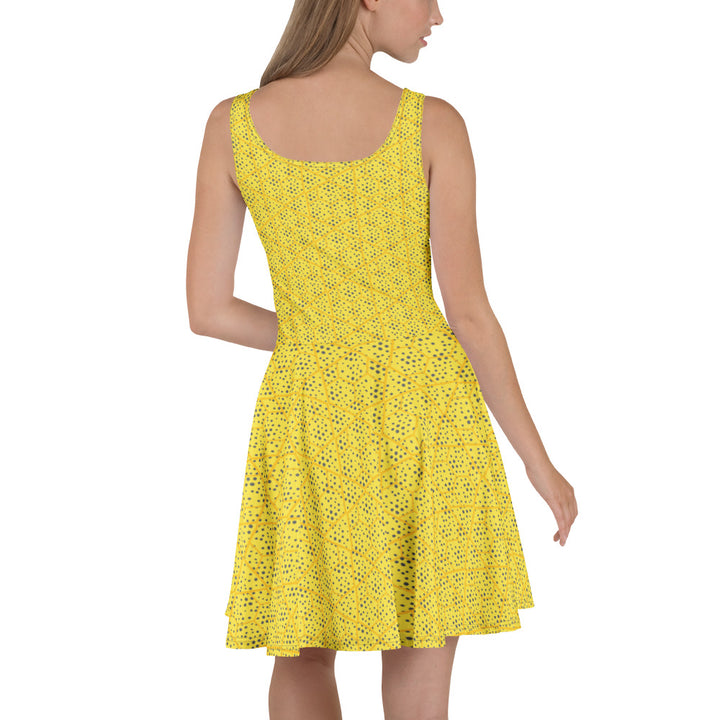 Achterkant van een model die de gele Measterwerk dames skaterjurk met all-over geometrische print draagt.