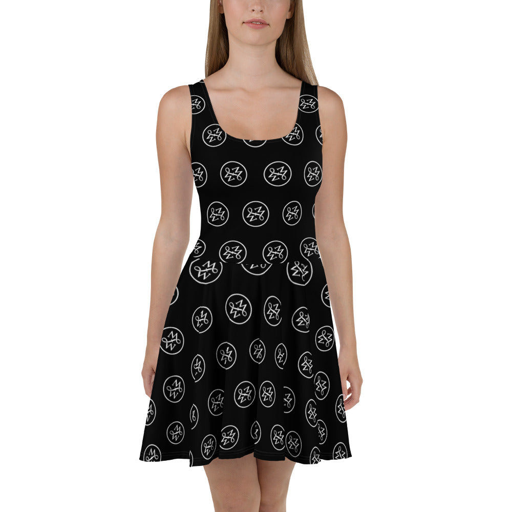 Sfeerfoto van een model in de Measterwerk dames skaterjurk zwart met een all over MW wit logo print, vooraanzicht.