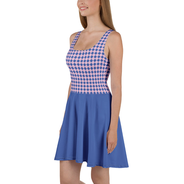 Model draagt de mouwloze Measterwerk skaterjurk blauw met een rose geruite bovenkant, gefotografeerd vanaf linksvoor.