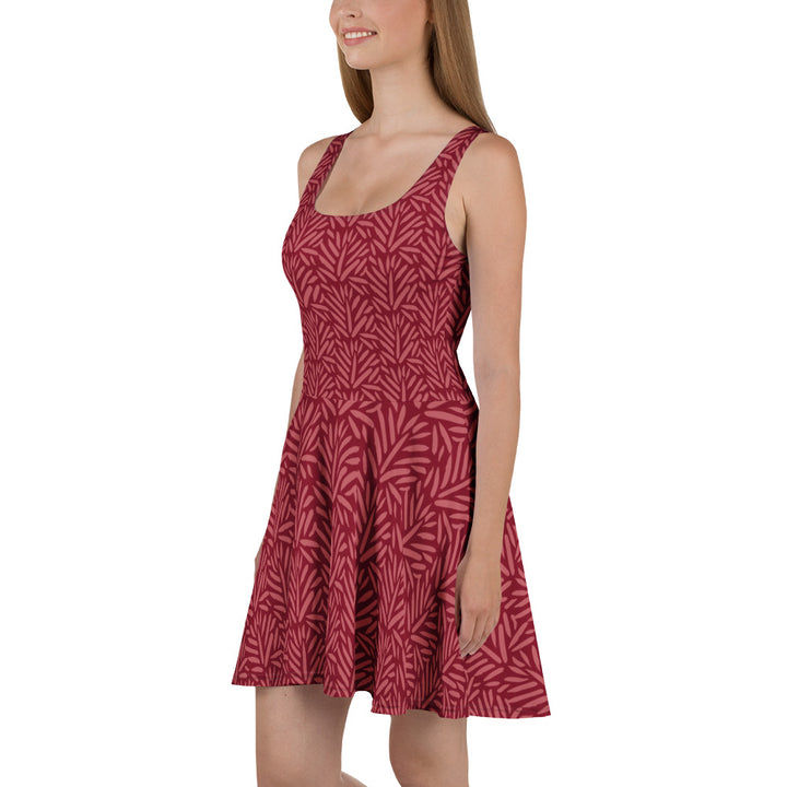 Model draagt de mouwloze Measterwerk skaterjurk met bloemenprint rood, gefotografeerd vanaf linksvoor.