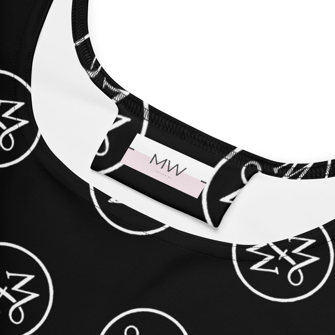 Close-up van het Measterwerk kledinglabel en het all-over geprinte MW wit logo op de zwarte skaterjurk.